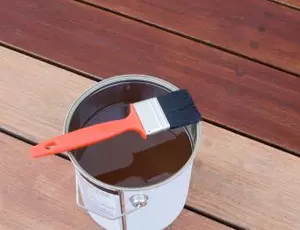 A can of wood stain on a porch