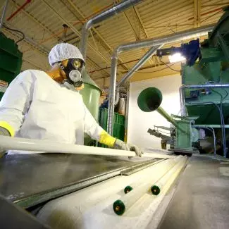 A Veolia employee handles a fluorescent light bulb