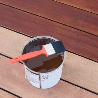 A can of wood stain on a porch
